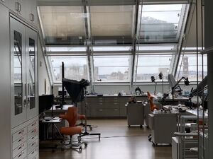 A picture of the sky camera used for this project, attached to the museum's glass ceiling inside a work area full of instruments used for art conservation.