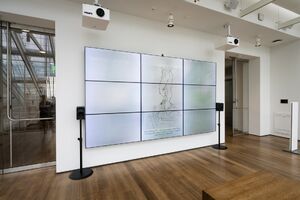 An installation shot of a Harvart Art Museum gallery with a large screen on the wall. The screen shows a picture of a drawing from the museum's digital collection on a blurred background of the sky. The image is captioned with the current weather (Overcast, 45°F) and the artwork's title and artist: Untitled by William Anastasi, 2003